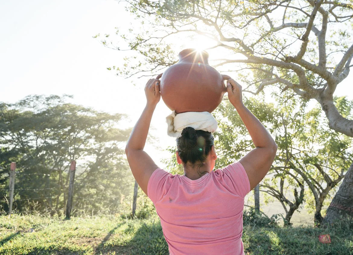 Woman carries a water vessel in Honduras